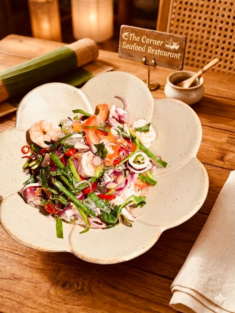 Thai-style seafood glass noodle salad with prawns, squid, chili and herbs on a flower-shaped plate, beside the restaurant's branded table sign