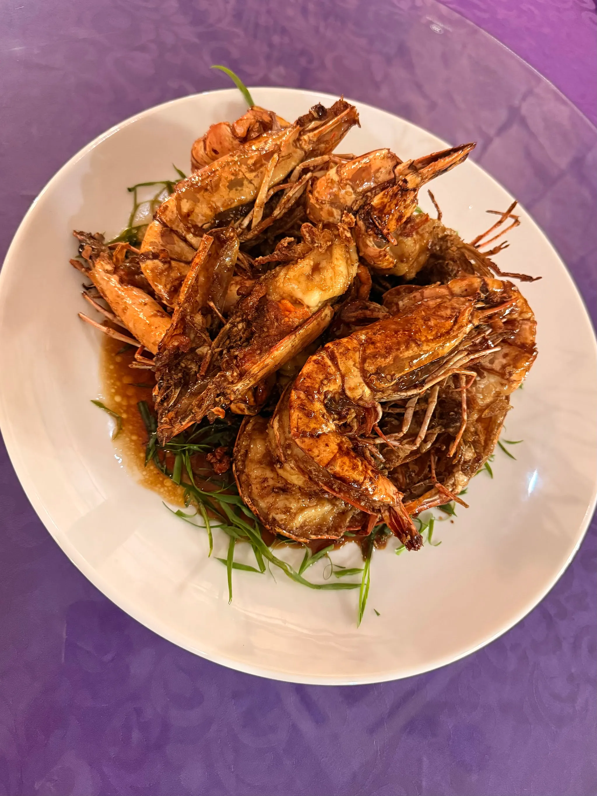 Whole tiger prawns wok-fried in a dark, glossy savoury sauce over spring onion
